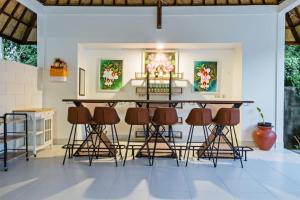 un bar al centro di una stanza con sgabelli di Kesari Glory Nusa Penida by GenuineHost a Nusa Penida