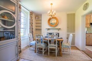 a dining room with a table and chairs at Peartree Cottage in Chippenham