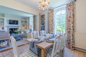 comedor y sala de estar con mesa y sillas en Peartree Cottage en Chippenham