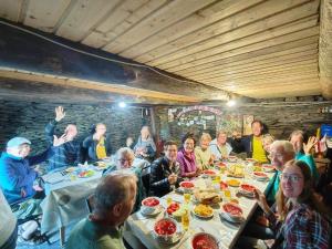 a group of people sitting at a table eating food at Hotel Omalo2005 in Omalo