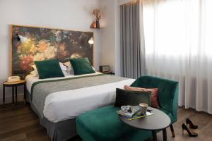 Cette chambre comprend un grand lit, une table et des chaises. dans l'établissement Hôtel Edmond W Lyon Part-Dieu, à Lyon