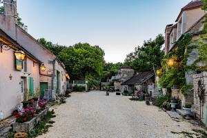 Chevroches的住宿－Le Domaine des Carriers，村里一条鹅卵石街道,有建筑