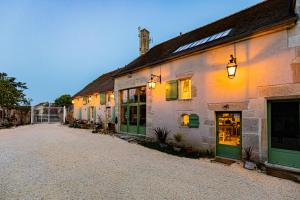 a building with green doors on a street at Le Domaine des Carriers in Chevroches