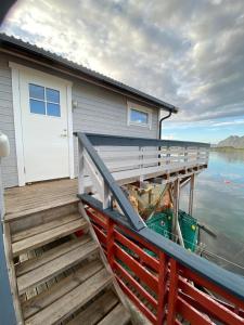 a house with a wooden deck on the water at Utsikten in Gjesvær