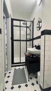 ein schwarzweißes Bad mit einem Waschbecken und einem Fenster in der Unterkunft Dům u Zeleného stromu in Sušice