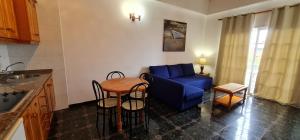 a living room with a blue couch and a table at Viviendas Vacacionales Escuela in Agulo