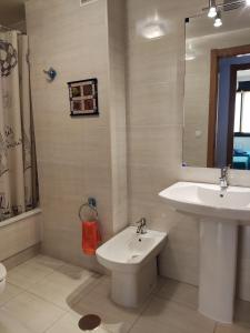 a bathroom with a sink and a toilet and a mirror at Apartamento Agarimo - La tranquilidad de una isla de menos de 5000 habitantes in Isla de Arosa +6 photos
