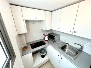 a small kitchen with a sink and a microwave at Demetra 1 Bdr Down Town Nicosia in Nicosia