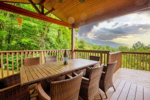 une table et des chaises en bois sur une terrasse en bois dans l'établissement --Mountain Chalet Getaway with Breathtaking View Next to Tail of Dragon--, à Robbinsville