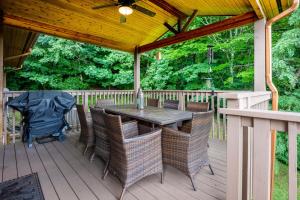 a wooden deck with a table and chairs on it at --Mountain Chalet Getaway with Breathtaking View Next to Tail of Dragon-- in Robbinsville