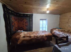 a bedroom with two beds in a room with wooden ceilings at Hotel Omalo2005 in Omalo