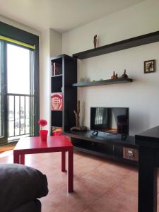 a living room with a fireplace and a red table at Apartamento Agarimo - La tranquilidad de una isla de menos de 5000 habitantes in Isla de Arosa