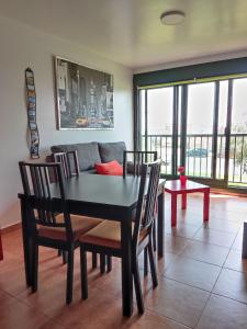 a dining room with a table and chairs and a couch at Apartamento Agarimo - La tranquilidad de una isla de menos de 5000 habitantes in Isla de Arosa