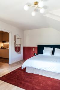 Un dormitorio con una gran cama blanca y una alfombra roja en Villa Parkbos, en De Pinte