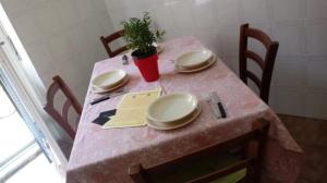 een roze tafel met platen en een potplant erop bij Hospiton Home in Cagliari