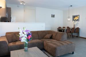 a living room with a couch and a vase of flowers on a table at Horsetellerie Rheezerveen in Hardenberg
