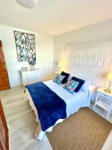 a bedroom with a large bed with blue sheets and pillows at Luxury Beach Fayna in Playa Honda