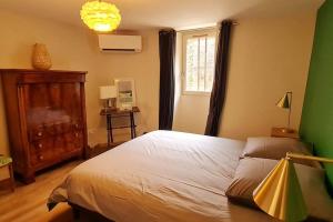 een slaapkamer met een bed en een groene muur bij Maison de charme - Au coeur de Puligny-Montrachet in Puligny-Montrachet