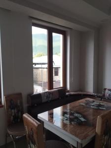 a living room with a table and a large window at Orkide in Sheki +3 photos