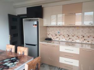 a kitchen with white cabinets and a refrigerator at Orkide in Sheki