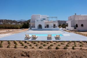a villa with a swimming pool in front of a house at Studio 28 in Naxos Chora