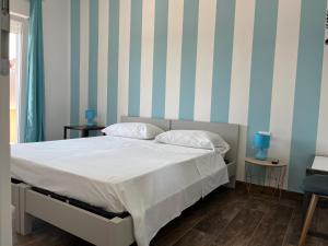 a bed in a room with blue and white stripes at B&B Sapore di Mare san salvo Marina in San Salvo