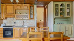 a kitchen with wooden cabinets and a table and chairs at Borgo San Valentino in Arrone
