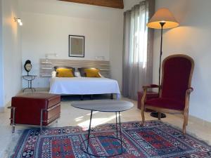 una camera da letto con un letto, un tavolo e una sedia di Les Moineaux a Rustrel