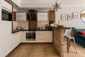 a kitchen with white cabinets and a counter top at Millo Apartament IMPERO z Parkingiem in Poznań