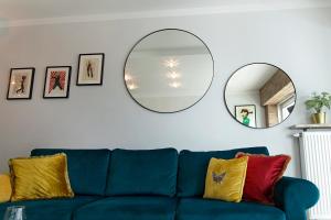 a blue couch in a living room with a mirror at Millo Apartament IMPERO z Parkingiem in Poznań