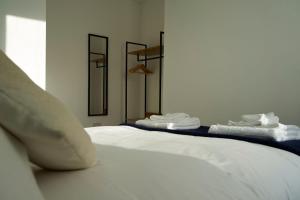 a bedroom with two beds with towels on them at K Suites - Wellington Street 1 in Gloucester