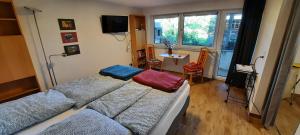 a bedroom with two beds and a desk and a window at Ferienwohnung Tuniberg in Umkirch