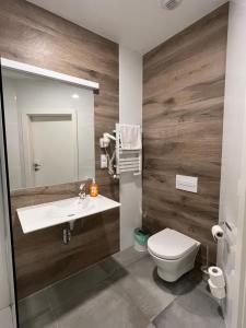 a bathroom with a toilet and a sink and a mirror at Aparthotel Apartamenty Czarna Góra 112 in Sienna +15 photos
