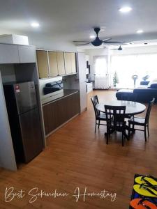 a kitchen and living room with a table and chairs at Best Sekinchan homestay in Sekinchan