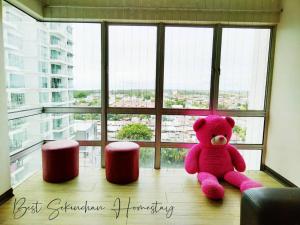 a pink teddy bear sitting in front of a window at Best Sekinchan homestay in Sekinchan
