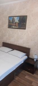 - une chambre avec un lit et une photo sur le mur dans l'établissement Apartments Ilona, à Odessa