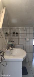 a white bathroom with a sink and a toilet at Apartment Marina in Brzac