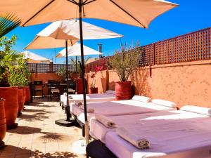 une rangée de tables avec parasols sur une terrasse dans l'établissement Riad Casa Lalla, à Marrakech