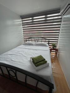 Schlafzimmer mit einem großen Bett und einem Fenster in der Unterkunft Jolie Joe's in Tagudin