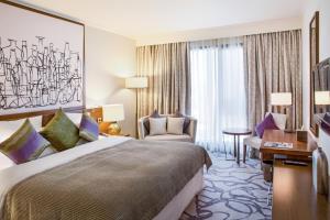 a hotel room with a large bed and a painting on the wall at Pullman Dubai Creek City Centre Residences in Dubai