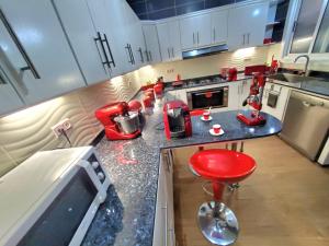 a kitchen with red appliances on a counter at Appartement LOUIS XIV avec HAMMAM SAUNA JACCUZI PRIVATISÉ TOTALEMENT GRATUIT SANS SUPPLÉMENT ! in Al Hoceïma