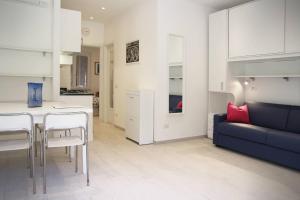 Appartamento L'ONDA - 1 via Provinciale في فيزانو: مطبخ وغرفة معيشة مع أريكة وطاولة