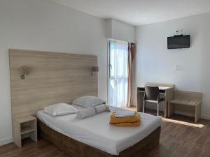 a bedroom with a bed with a desk and a television at Auberge de Jeunesse in La Rochelle