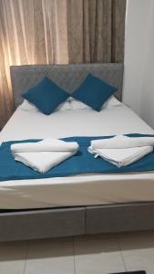 a bed with blue and white pillows on it at Huge Evleri 2 in Marmaris