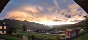 a view of a cloudy sky over a town at Un bel panorama in un ambiente famigliare in Tesero