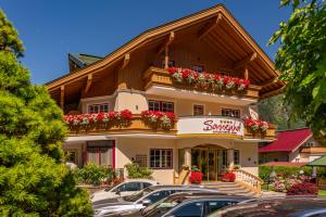 hotel z samochodami zaparkowanymi na parkingu w obiekcie Apparthotel Sonnenhof w Mayrhofen