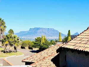 a view of the table mountain from the roofs of houses at Hotel Vibes Cape Town Plattekloof in Cape Town