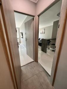 um corredor com portas de vidro deslizantes e uma sala de estar em Apartament Portowa K2 em Kolobrzeg