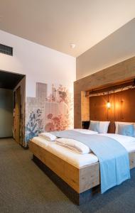 a bedroom with a large bed with a wooden headboard at RiKu HOTEL Göppingen in Göppingen