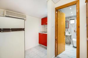 a kitchen with a refrigerator and a red cabinet at Kalogeraki Studios in Potos